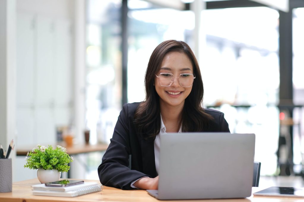 Young Asian businesswoman is happy to work at the modern office using a tablet.